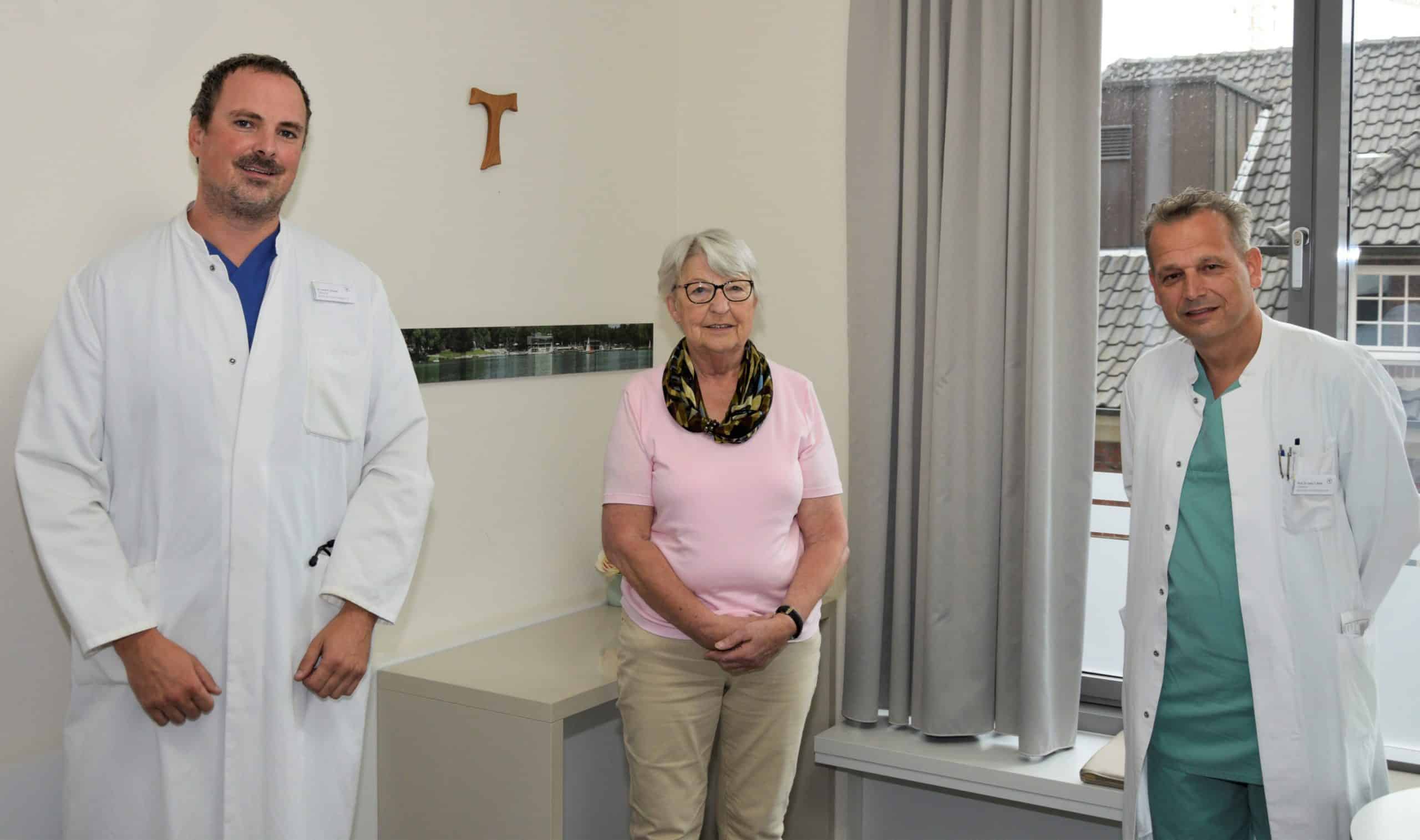 Erste Patientin im St. Franziskus-Hospital (M.) wurde mit dem neuem PASCAL-Verfahren an der Trikuspidal-Herzklappe behandelt. Chefarzt Prof. Dr. Sebastian Reith (r.) und Oberarzt Dr. Patrick Struwe freuen sich mit ihr über den OP-Erfolg.