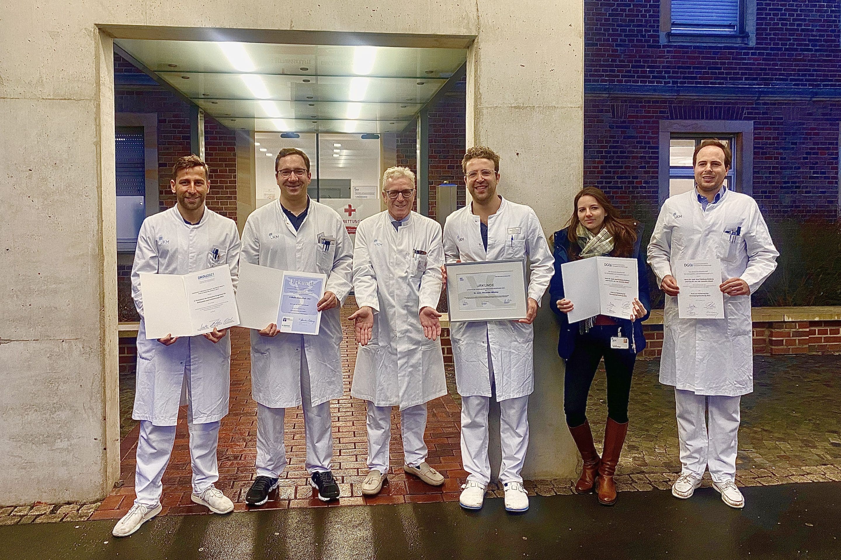 Allein der Chef steht mit leeren Händen da: Klinikdirektor Prof. Michael Raschke (3.v.r) mit seinen prämiierten Mitarbeitenden (v.l.n.r.) Dr. Johannes Glasbrenner, Priv.-Doz. Dr. Elmar Herbst, Dr. Alexander Milstrey, Dr. Jeanette Köppe und Dr. Josef Stolberg-Stolberg (Foto: privat)