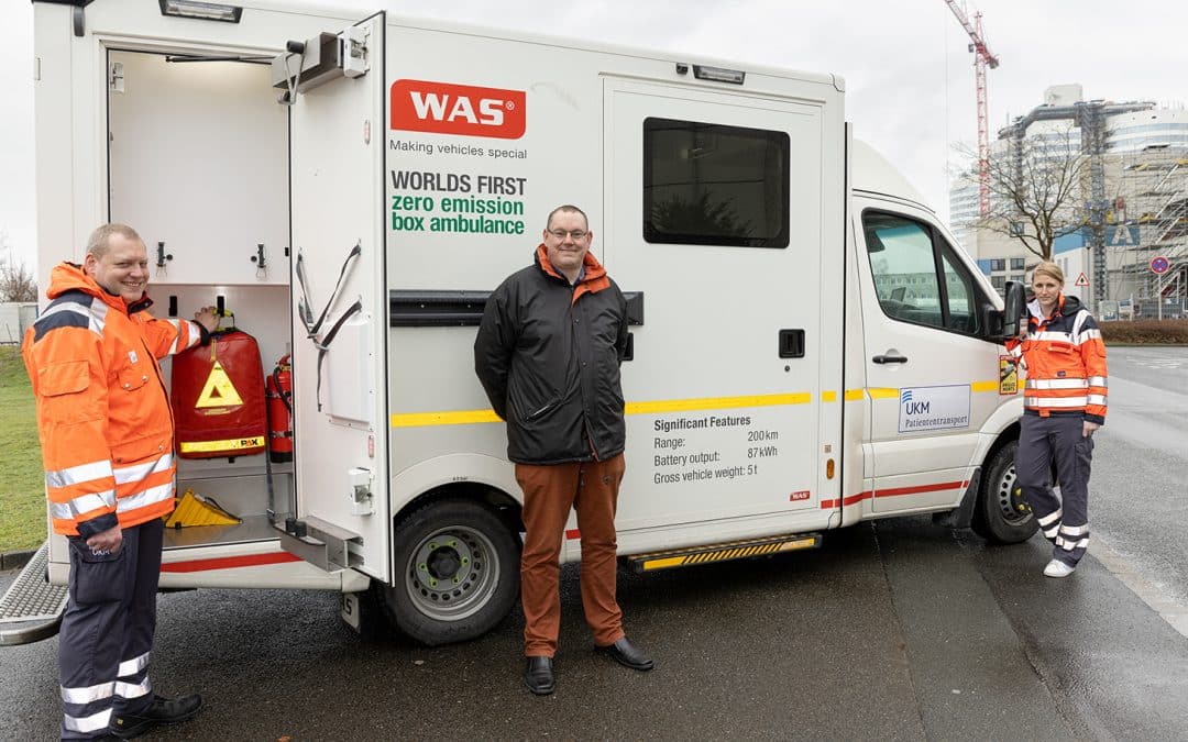 e-RTW: Foto (UKM/Leßmann): Emissionsfrei und komfortabel: Aktuell testen Anja Maibaum und Matthias Siegemeyer (l.), beide Mitarbeitende des Patiententransportes am UKM, und André Saphörster, Leiter des Patiententransport- und Botendienstes am UKM, einen voll elektrisch angetriebenen Rettungswagen im Patiententransport.