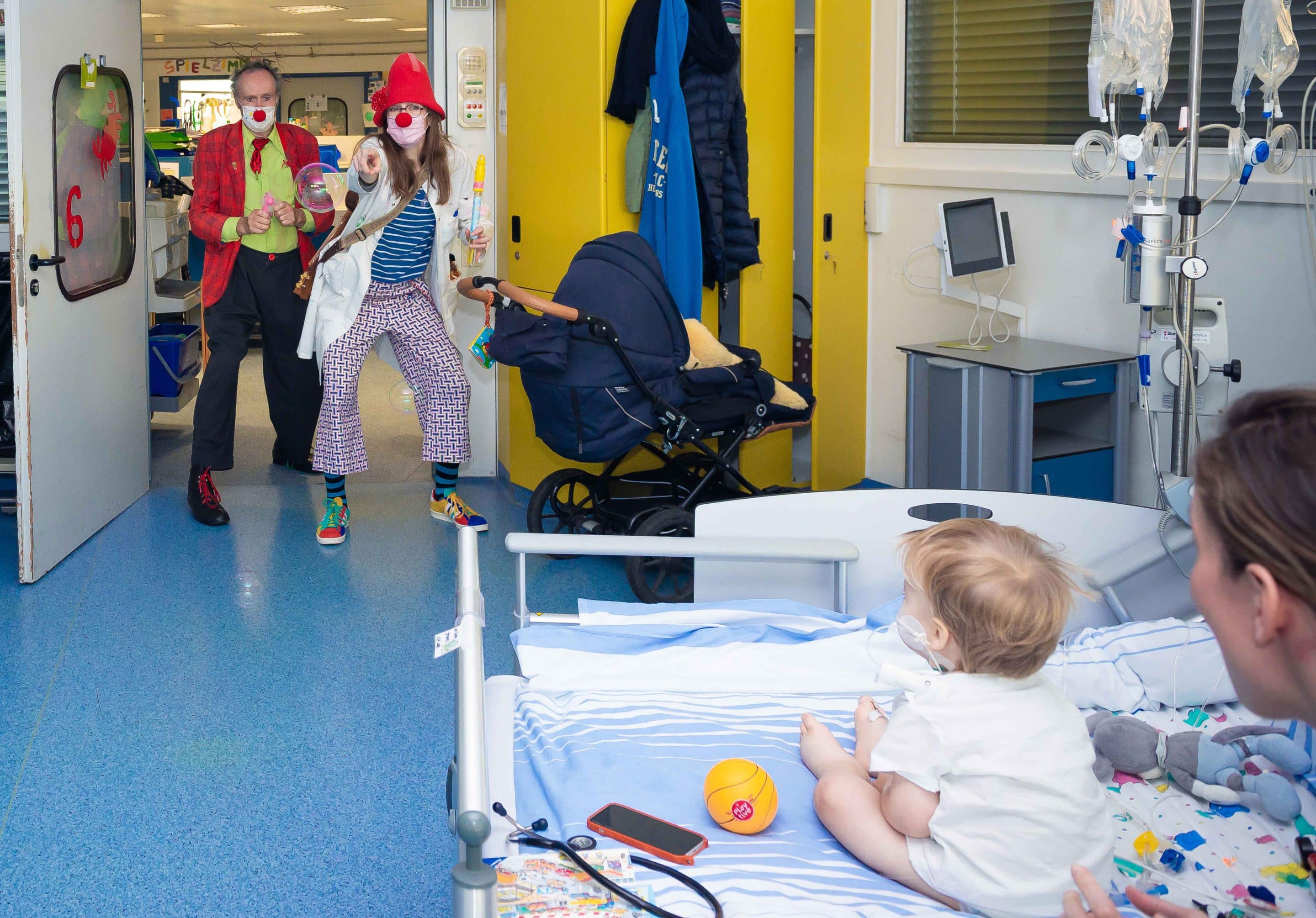 UKM_Stationsrundgang_mit_Lollo_01 Nur ein Beispiel, in Zeiten der Pandemie auf schöne Art den Abstand zu überbrücken: Clownin Lollo (hier zusammen mit Clown Konrad) schickt einem Kleinkind Seifenblasen zum Bett.