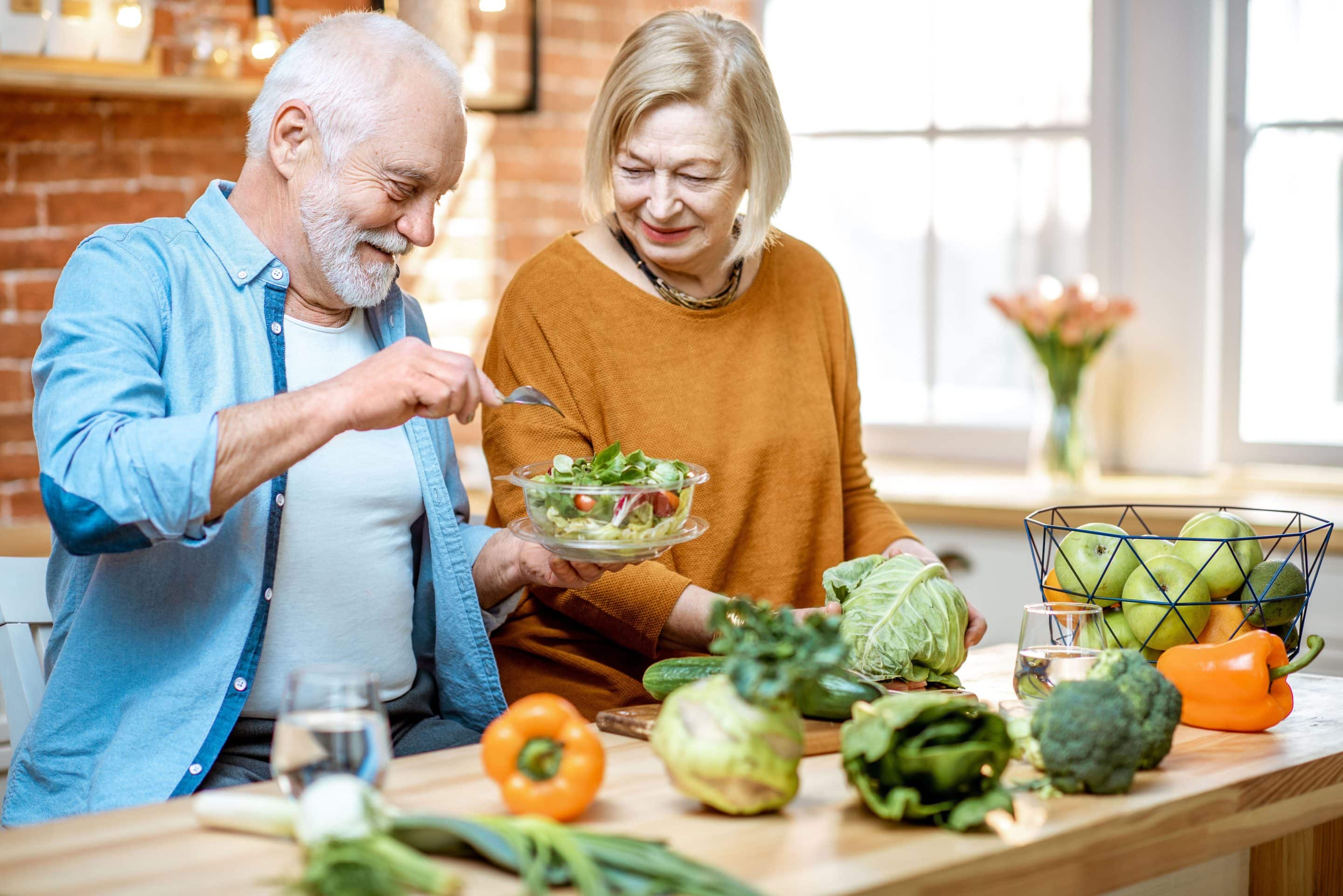 Senior couple with healthy food at home Arteriosklerose ausbremsen: Gemüse und Obst liefern viele Vitamine und sekundäre Pflanzenstoffe, die die Gefäßgesundheit unterstützen. Foto: djd/Telcor-Forschung/rh2010 - stock.adobe.com