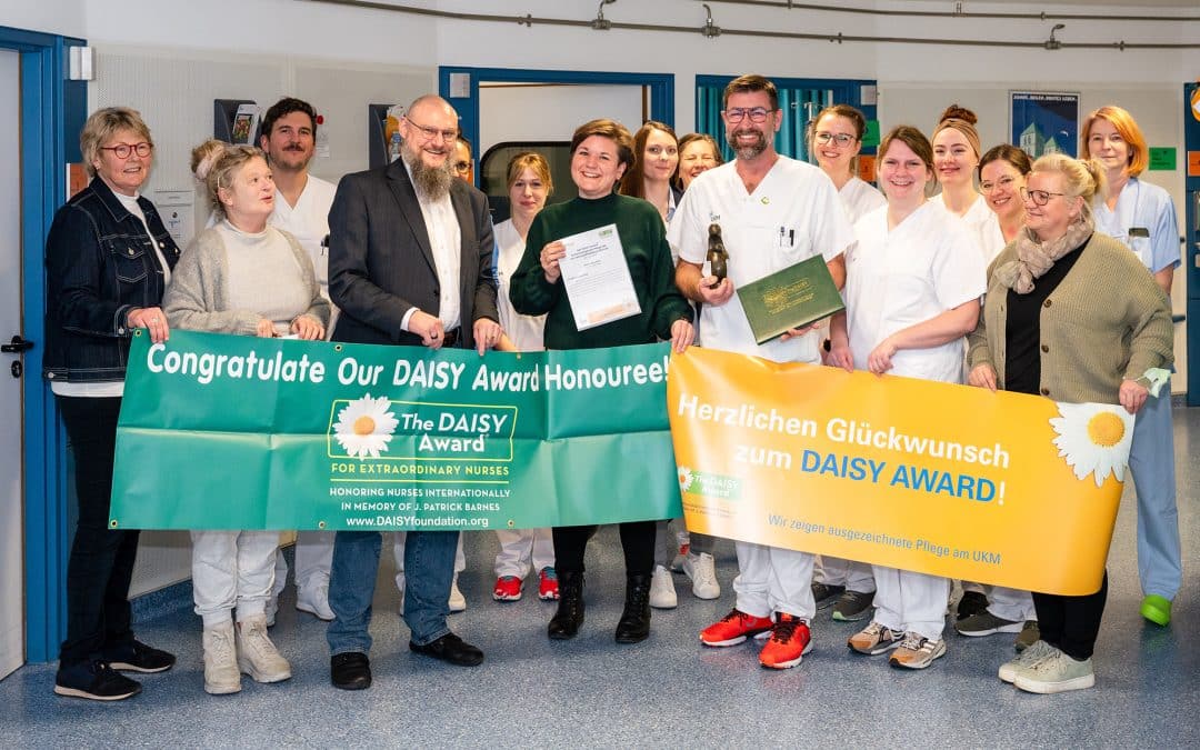 DAISY Award: Überraschungsbesuch auf der Station 15 B West: Pflegedirektor Thomas van den Hooven (3.v.l.) und das gesamte Team der onkologischen Tagesklinik gratuliert dem ersten DAISY Award-Preisträger Gesundheits- und Krankenpfleger Martin Beerhorst (3.v.r.). (UKM/Heine)