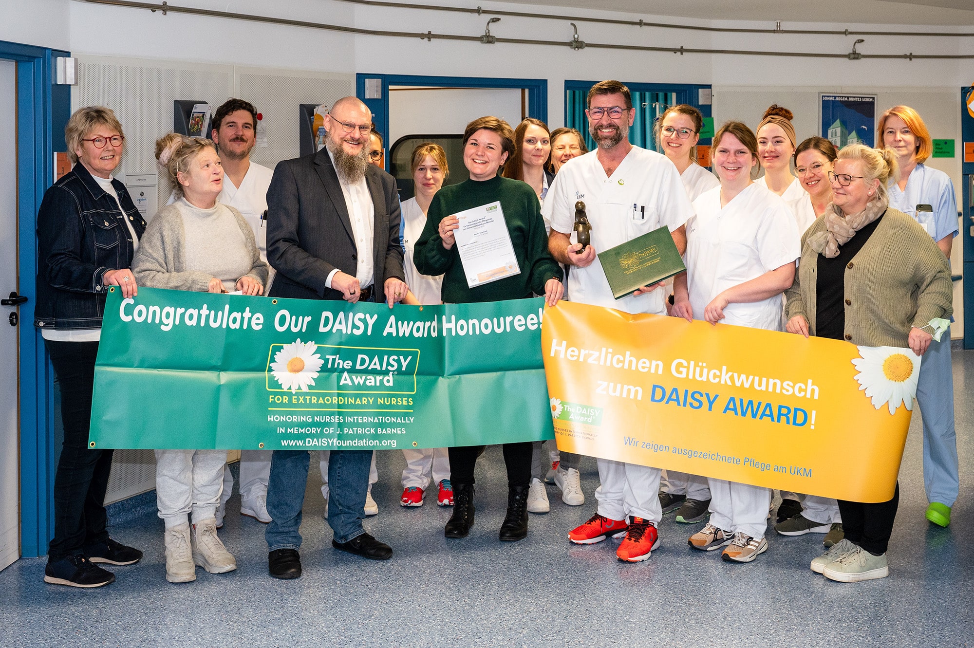 DAISY Award: Überraschungsbesuch auf der Station 15 B West: Pflegedirektor Thomas van den Hooven (3.v.l.) und das gesamte Team der onkologischen Tagesklinik gratuliert dem ersten DAISY Award-Preisträger Gesundheits- und Krankenpfleger Martin Beerhorst (3.v.r.). (UKM/Heine)