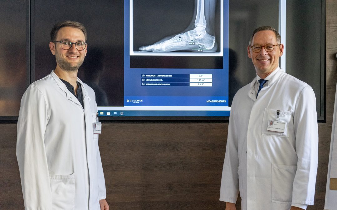 Oberarzt Dr. Markus von Wardenburg (li.) und Prof. Dr. Johannes Wessling (re.) vor einer Röntgenaufnahme, die von der KI überprüft wurde.