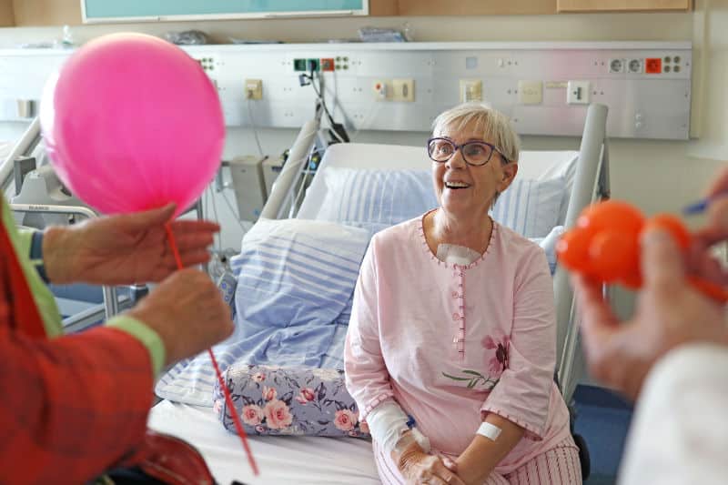 Conrad und Professor Spaghetti sprechen mit einer Patientin und basten kleine Luftballon-Aufmerksamkeiten für sie. (© Foto by UKM)